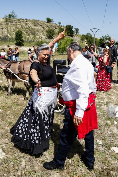 Dos asistentes a la celebración bailan en el descampado. 