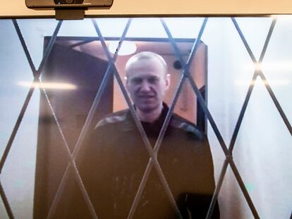 Russian opposition leader Alexei Navalny is seen on a TV screen as he appears in a video link provided by the Russian Federal Penitentiary Service from the courtroom in Kovrov, Vladimir region, Russia, Jan. 10, 2024.