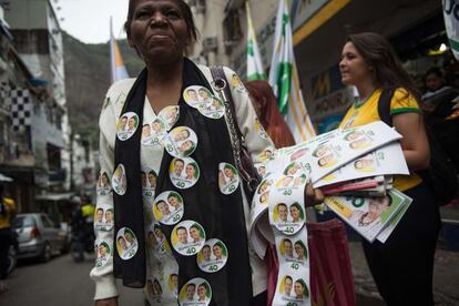 Uma mulher distribui adesivos a favor da candidatura de Marina Silva na favela da Rocinha, no Rio de Janeiro.