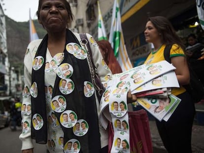 Uma mulher distribui adesivos a favor da candidatura de Marina Silva na favela da Rocinha, no Rio de Janeiro.