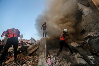 Varias personas buscan supervivientes entre los escombros de un edificio en Jan Yunis, en la franja de Gaza.