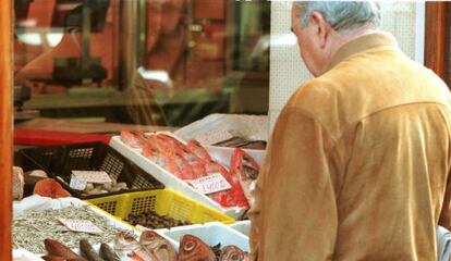 Un hombre, frente a una pescadería de Bilbao.