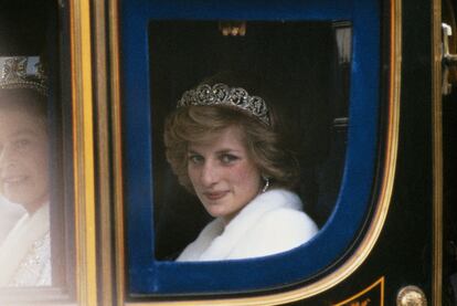 Diana de Gales, junto a la reina Isabel II, en la apertura del parlamento británico, en noviembre de 1982, vestida con un abrigo de piel blanco y portando la tiara Spencer.