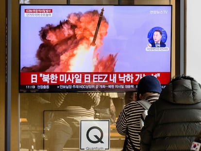 Varias personas observan una pantalla que emite imágenes del misil lanzado por Corea del Norte, este viernes en una estación de trenes en Seúl.