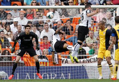 Javi Fuego y Paco Alcácer intentan un remate ante el portero del Atlético de Madrid Thibaut Courtois