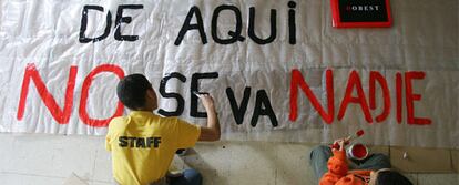 Dos niños pintan una pancarta con un lema de resitencia ante la decisión del Arzobispado de Madrid de desalojar la iglesia de Entrevías.