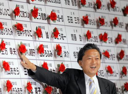 Yukio Hatoyama, ganador de las elecciones, tras un cartel en el que se han señalado con rosas los candidatos de su partido que logran escaño.