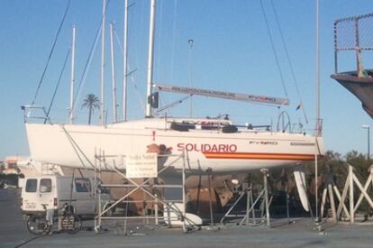 Un operario retira la marca Solidària del casco del barco subvencionado por la Generalitat.