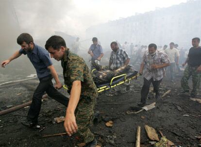 Varios ciudadanos llevan una camilla con él cadáver de una de las víctimas de la explosión.
