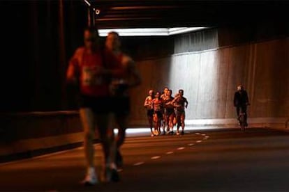 Participantes en el maratón popular de Valencia, ayer, a su paso por el túnel de La Petxina.