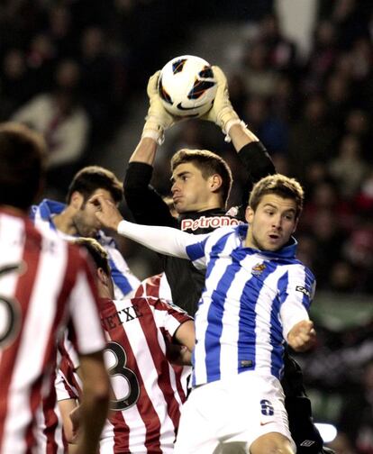 El portero del Athletic Raúl Fernández atrapa el balón ante Íñigo Martínez.