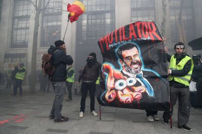 'Chalecos amarillos' sujetan una pancarta con la imagen del Ministro del Interior francés, Christophe Castaner, durante la protesta de este sábado en París (Francia).