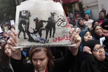 Una mujer muestra las imágenes de la policía pegando a una manifestante, ayer en El Cairo.