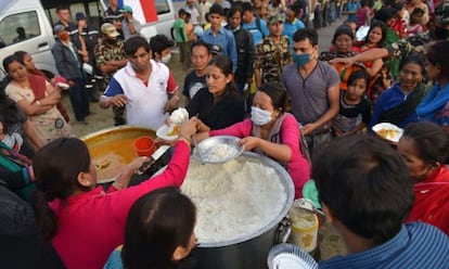 Nepal&iacute;es hacen cola para recibir comida, este viernes en Katmand&uacute;.