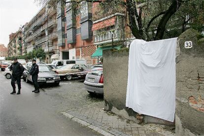 Tapada con una sábana, la entrada a la vivienda en la que se produjo el triple asesinato.