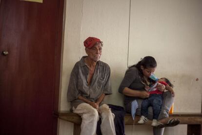 Un anciano con síntomas del virus espera junto a una mujer y su hijo en el centro de salud.