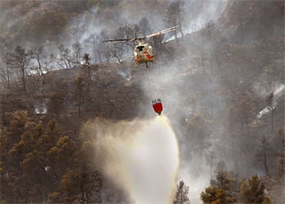 Un helicóptero descarga agua en la zona más alta del incendio de Sorita, ayer.