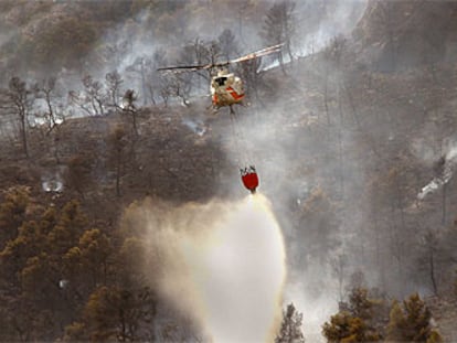 Un helicóptero descarga agua en la zona más alta del incendio de Sorita, ayer.