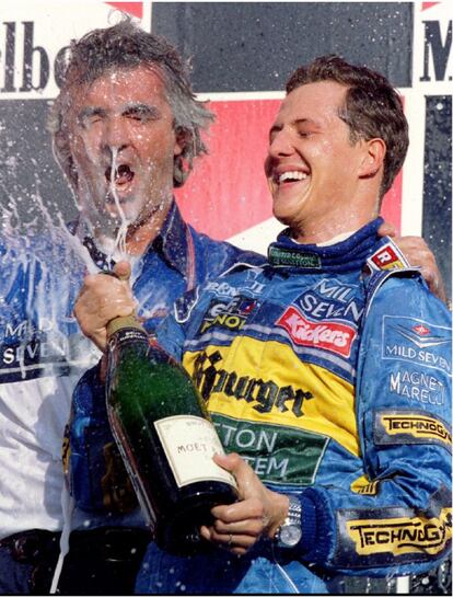 Michael Schumacher, piloto alemán de Benetton, rocía con champán al director del equipo, Flavio Briatore, tras ganar el Gran Premio del Pacífico de Fórmula 1, en el circuito de Aida el 22 de octubr de 1995
