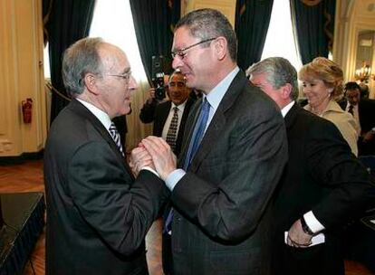 Alberto Ruiz-Gallardón saluda a Manuel Pizarro, con Esperanza Aguirre al fondo.