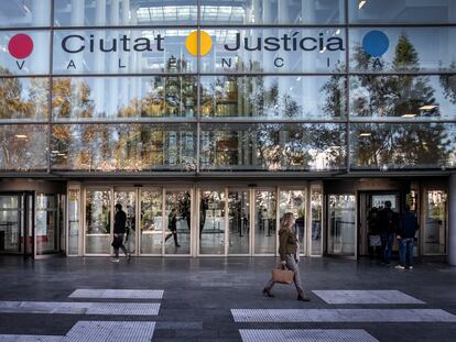 Imagen de archivo de una mujer que pasa por delante de la fachada de la Ciudad de la Justicia en València.