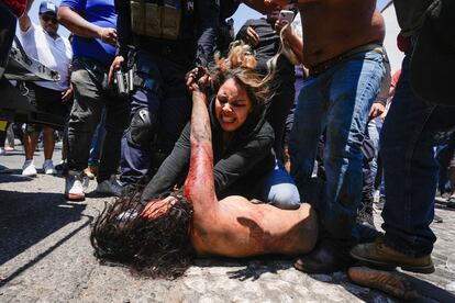 Una turba golpea a una mujer sospechosa de secuestrar y matar a Camila, una niña de 8 años, en Taxco, Guerrero, el jueves 28 de marzo de 2024. La multitud la arrastró fuera de un vehículo policial tras su detención. La fiscalía del Estado de Guerrero confirmó más tarde que la mujer murió a causa de las heridas.
