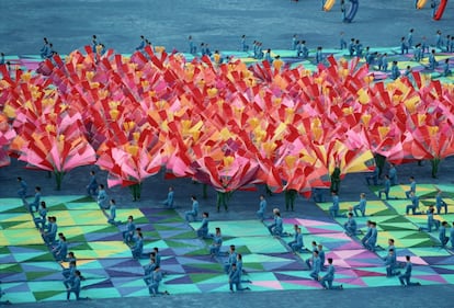 Un grup de ballarins onegen banderes de colors en un dels espectacles que van formar part de la inauguració dels Jocs, a Barcelona.