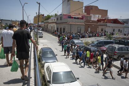 Cientos de personas hacen cola a las puertas de la mezquita Sidi Embarek, en Ceuta, durante el reparto de comidas de la asociación Luna Blanca. Cáritas y Luna Blanca han estado proporcionando entre 1.000 y 1.700 comidas calientes diarias para quienes han quedado atrapados en la ciudad tras la crisis fronteriza.