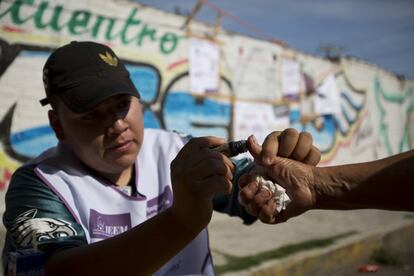 Un trabajador electoral marca el pulgar de un hombre con tinta después de que votara por gobernador en una mesa electoral en Chicoloapan de Juárez, Estado de México.