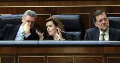 El ministro de Justicia, Alberto Ruiz Gallardón (i), conversa con la vicepresidenta del Gobierno, Soraya Sáenz de Santamaría (c), junto al presidente del Ejecutivo, Mariano Rajoy (d), durante un pleno extraordinario en el Congreso. EFE/Archivo