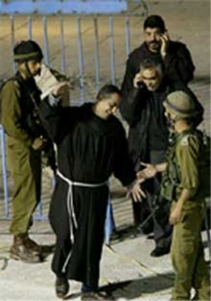 Un religioso saluda a soldados israelíes tras su salida del templo de la Natividad.