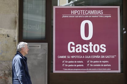 Un hombre pasa ante un anuncio de hipotecas en una sucursal bancaria en Madrid.