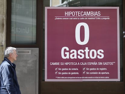 Un hombre pasa ante un anuncio de hipotecas en una sucursal bancaria en Madrid.