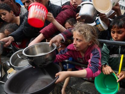 Menores palestinos esperan para recibir comida en una cocina solidaria en Rafah, al sur de Gaza, este martes.