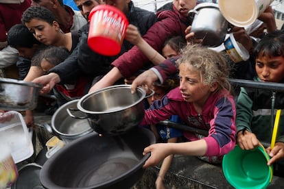 Menores palestinos esperan para recibir comida en una cocina solidaria en Rafah, al sur de Gaza, este martes.