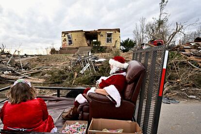 Dos vecinos vestidos de Papá Noel de Dawson Springs pasan por una casa destruida por los tornados que arrasaron el estado de Kentucky, el viernes.