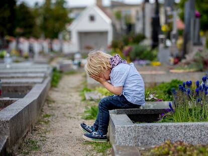 Un niño llora en un cementerio.