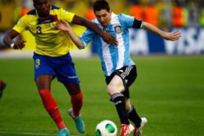 El jugador de Ecuador Fricson Erazo (i) disputa un balón con Lionel Messi (d) de Argentina hoy, martes 11 de junio de 2013, durante un partido por las eliminatorias a la Copa Mundo de Brasil 2014 en el estadio Atahualpa en Quito (Ecuador).