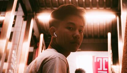 Chico utilizando unos AirPods de Apple