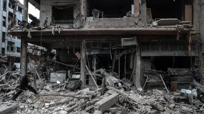 Vecinos inspeccionan los edificios en ruinas despu&eacute;s de varios bombardeos en Guta Oriental (Siria).