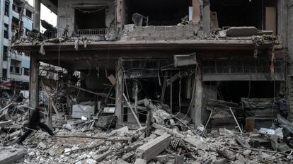 Vecinos inspeccionan los edificios en ruinas después de varios bombardeos en Guta Oriental (Siria).