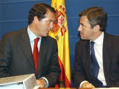 José María Michavila, izquierda, conversa con Ángel Acebes, durante la rueda de prensa para informar de la entrada en vigor de los juicios rápidos.