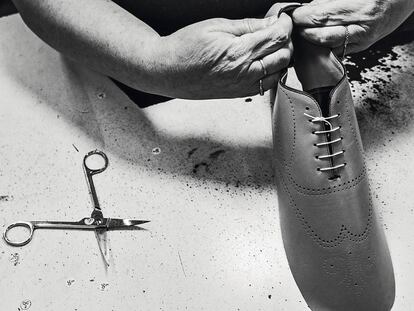 Un artesano trabaja en la costura del talón de un zapato.