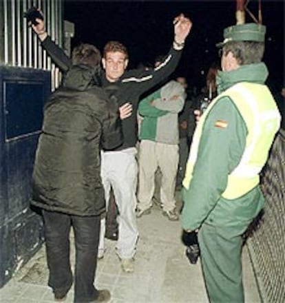 Un vigilante de seguridad cachea a un joven en presencia de la Guardia Civil a la entrada de la fiesta de Armilla.