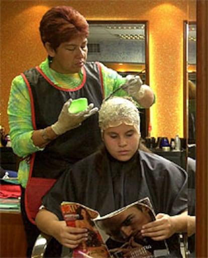 Una peluquera tiñe el pelo a una mujer en una peluquería de Caracas (Venezuela).