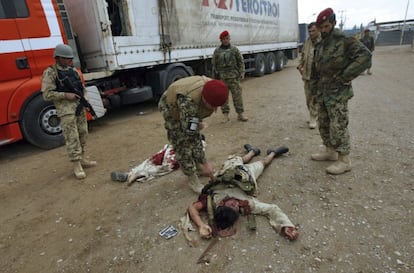 Soldados afganos inspeccionan los cadáveres de dos presuntos insurgentes talibanes en el lugar tras el atentado suicida.