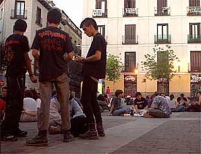 Grupos de jóvenes en la plaza de San Ildefonso con pancartas de protesta al fondo.