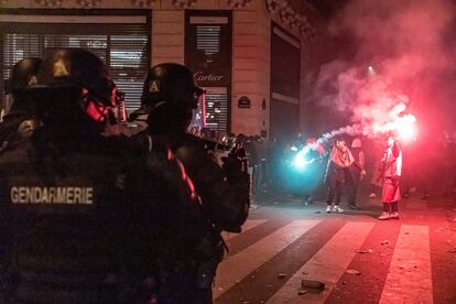 Miembros de la policía francesa observan las celebraciones de la hinchada marroquí en los Campos Elíseos de París.