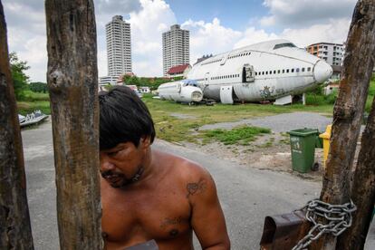 Un hombre en la entrada del área conocida como el "cementerio de aviones", convertida en una atracción turística en Bangkok.  