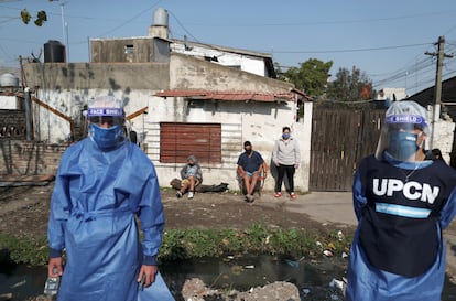 Dos trabajadores sanitarios, a principios de agosto con vecinos de Villa Fiorito (Buenos Aires, Argentina).